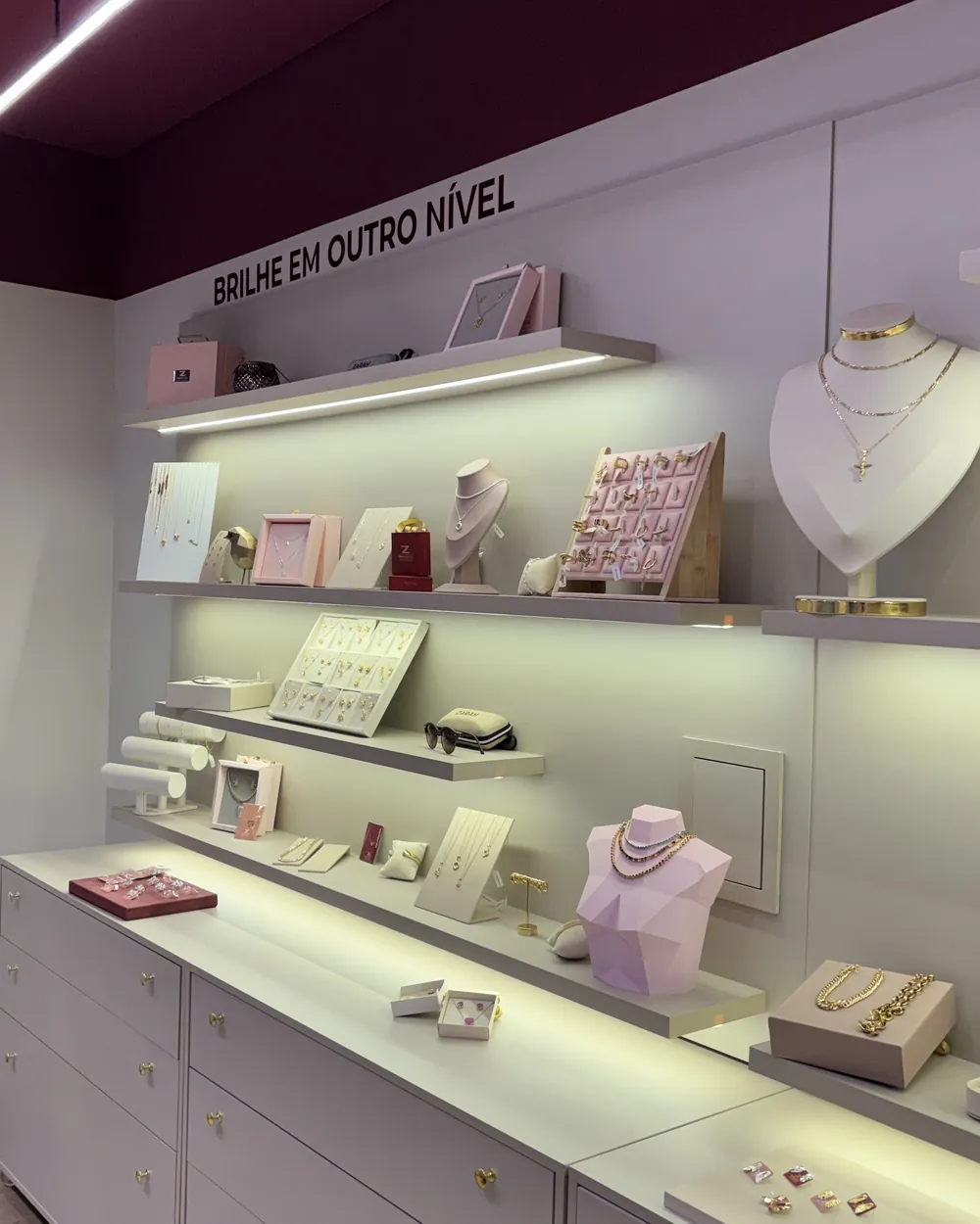 Interior da loja ZAVORA com prateleiras iluminadas e joias expostas